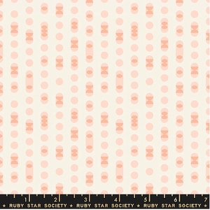 May include: A white fabric with a repeating pattern of pink and peach circles and ovals. The pattern is subtle and elegant.
