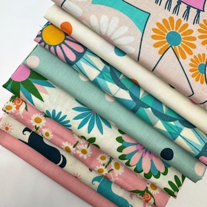 May include: A stack of eight fabric squares with various patterns featuring geometric shapes, flowers, and abstract designs in shades of pink, blue, white, and yellow.