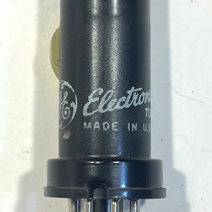 May include: A black electronic tube with the text "Electron Tube" and "Made in U.S." printed in white. The tube has a cylindrical body and a base with multiple pins.