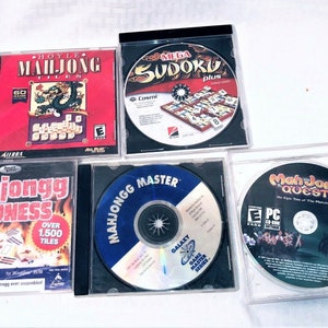 May include: A collection of five computer game CDs in clear plastic cases. Titles include "Hoyle Mahjong Tiles," "Mega Sudoku Plus," "Mahjongg Madness," "Mahjongg Master," and "Mah Jong Quest." The game discs feature colorful graphics and text.