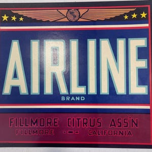 May include: Vintage Airline Brand citrus fruit crate label. The label features the word "AIRLINE" in large white letters against a blue background. The label also includes the words "BRAND", "FILLMORE CITRUS ASS'N", "FILLMORE", and "CALIFORNIA". The top of the label has a design of wings and stars.