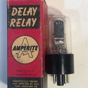 May include: Vintage Amperite Delay Relay in its original red and black box. The box features the text "DELAY RELAY" and "AMPERITE". The relay is a clear glass tube with a black base and multiple pins, made in the U.S.A.