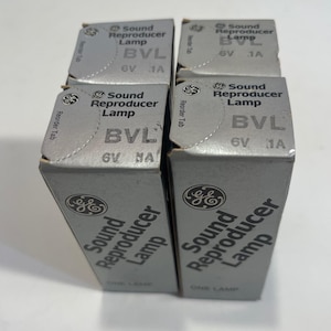 May include: Four silver boxes of "Sound Reproducer Lamp" bulbs. Each box has the GE logo and the text "BVL 6V 1A". The boxes are stacked together, with the tops visible, displaying the product information.