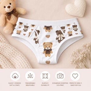 Puede incluir: Bragas blancas con un estampado repetido de ositos de peluche marrones, cada uno con una pajarita. Las bragas tienen una cintura blanca y detalles de corazones marrones. También se ve el texto "SOFT & COMFY", "BREATHABLE", "FLEXIBLE FIT", "FUN PRINT" y "MADE FOR YOU".
