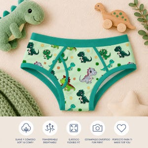 Puede incluir: Ropa interior verde claro con un divertido estampado de dinosaurios. La ropa interior tiene un ribete verde azulado y presenta varios dinosaurios de dibujos animados. La imagen también incluye un dinosaurio de peluche verde, un juguete de dinosaurio de madera e iconos con texto.