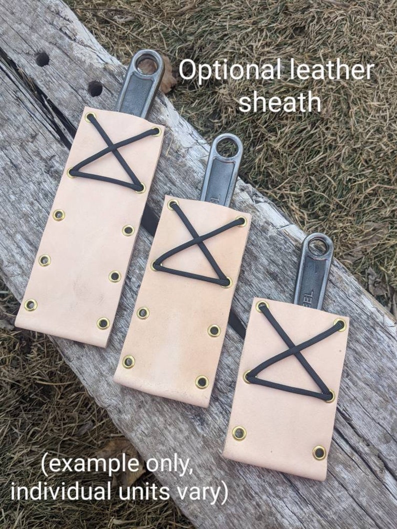 K&ouml;nnte beinhalten: Drei Ledertaschen mit schwarzen Gummib&auml;ndern und Messingnieten. Die Taschen sind f&uuml;r Schraubenschl&uuml;ssel konzipiert. Der Text "Optional leather sheath" ist &uuml;ber den Taschen sichtbar. Der Text "(example only, individual units vary)" ist unter den Taschen sichtbar.