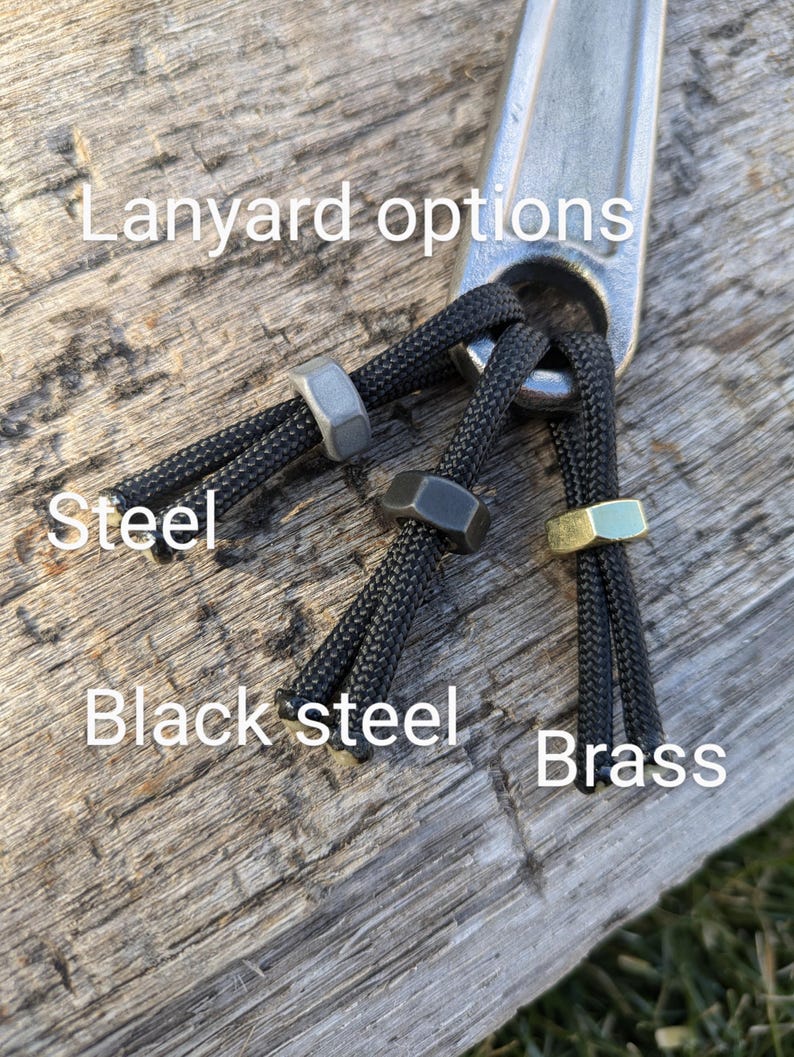 K&ouml;nnte beinhalten: Lanyard-Optionen f&uuml;r einen Schraubenschl&uuml;ssel, gezeigt mit drei verschiedenen Perlenfarben: Stahl, Schwarzstahl und Messing. Der Text "Lanyard options" ist im Bild sichtbar.