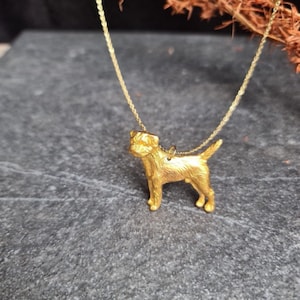 Op de afbeelding: Een gouden ketting met een gedetailleerde, driedimensionale hanger in de vorm van een terriër.
