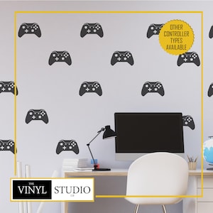 May include: A set of dark grey video game controller wall decals arranged in a repeating pattern on a light wall. A yellow circular badge in the upper right corner features the text OTHER CONTROLLER TYPES AVAILABLE in black lettering.