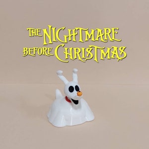 May include: White plastic figurine of Zero, the ghost dog from the movie "The Nightmare Before Christmas". Zero is wearing a red collar and has a glowing orange nose.