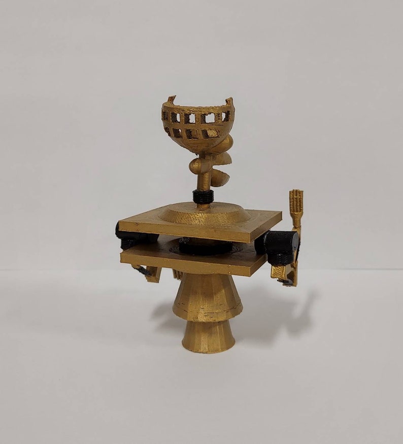 May include: A gold-colored 3D printed model of a satellite with a dish antenna and a rotating arm. The model is on a white background.