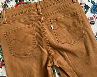 Puede incluir: Un par de pantalones vaqueros de color marrón con un parche de Levi's en la parte posterior de la cintura.