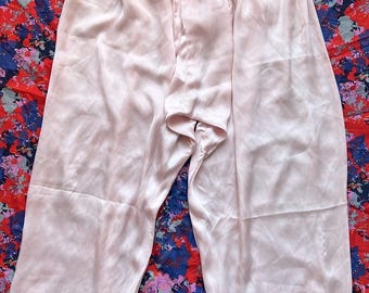 May include: A pair of light pink satin pajama pants with a drawstring waistband.