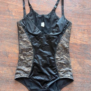 Peut inclure: Body noir avec des détails en dentelle sur les côtés. Le body a des bretelles réglables et une finition lisse et soyeuse.