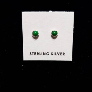 May include: A pair of sterling silver stud earrings with green stones.