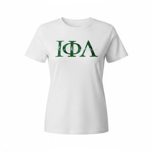 May include: White t-shirt with a green Greek letter design. The letters are I, Φ, and Λ. The shirt is made of a soft material and has short sleeves. The design is centered on the front of the shirt.