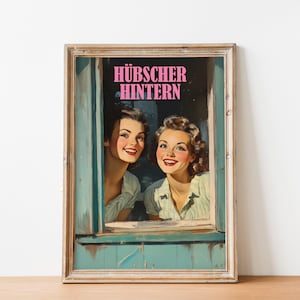 Könnte beinhalten: Ein gerahmter Vintage-Druck von zwei Frauen, die aus einem Fenster schauen. Die Frauen lächeln und tragen Kleidung im Stil der 1950er Jahre. Der Text "HÜBSCHER  HINTERN" ist in pinken Buchstaben oben im Bild gedruckt.