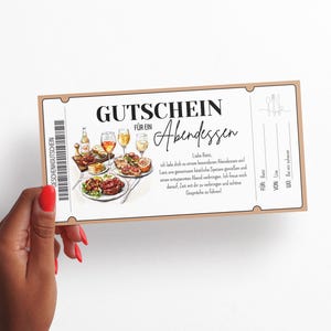 Op de afbeelding: Een cadeaubon voor een diner, vastgehouden door een hand met rode nagellak. De bon heeft een bruine rand en bevat illustraties van eten en drinken. Tekst bevat "GUTSCHEIN F&Uuml;R EIN Abendessen" en andere Duitse tekst.