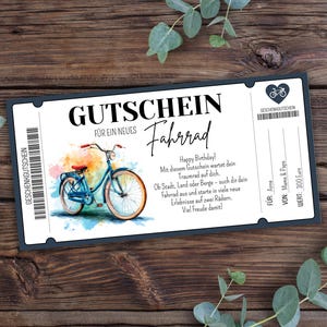May include: A gift certificate for a new bicycle with a watercolor illustration of a blue bicycle. The text includes "Happy Birthday!" and other German text. The certificate is on a dark wood background.