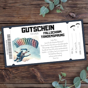 Puede incluir: Un vale de regalo en blanco y negro para una experiencia de paracaidismo en tándem. El vale de regalo presenta un paracaídas colorido y dos paracaidistas en el cielo. El texto en el vale de regalo dice "Gutschein für einen Fallschirm Tandemsprung".