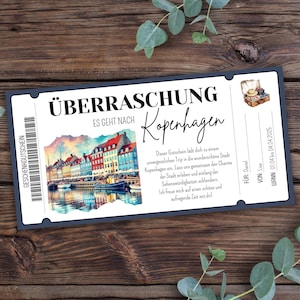 Pode incluir: Um vale-presente azul e branco com o texto "ÜBERRASCHUNG" e "ES GEHT NACH Kopenhagen". O vale-presente apresenta uma ilustração em aquarela de uma cidade com edifícios coloridos e uma massa de água.