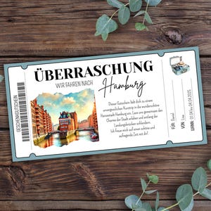 Könnte beinhalten: Ein blaues und weißes Ticket mit dem Text "Überraschung" und "Wir fahren nach Hamburg". Das Ticket zeigt eine Aquarell-Illustration des Hamburger Hafens mit Gebäuden und einem Kanal. Der Text "Dieser Gutschein lädt dich zu einem unvergesslichen Kurztrip in die wunderschöne Hansestadt Hamburg ein. Lass uns gemeinsam den Charme der Stadt erleben und entlang der Landungsbrücken schlendern. Ich freue mich auf eine schöne und aufregende Zeit mit dir!" ist ebenfalls enthalten.