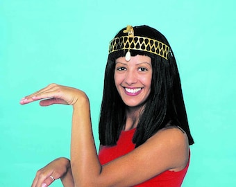 Peut inclure: Une femme portant une couronne dorée avec un bijou blanc et un haut rouge sans manches sourit et tend les mains devant elle.