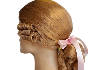 Könnte beinhalten: Eine blonde Perücke mit einem seitlichen Zopf und einem rosa Band, das am Ende gebunden ist. Die Perücke ist in einer klassischen Hochsteckfrisur mit Locken gestylt.