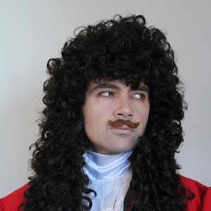 May include: A man dressed as Captain Hook from Peter Pan. He is wearing a red and black costume with a white lace shirt and a brown mustache. He is holding a silver hook in his right hand.