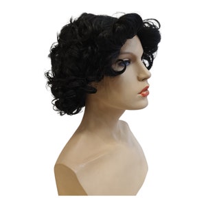 Könnte beinhalten: Eine schwarze lockige Perücke auf einem Mannequin-Kopf. Die Perücke hat einen kurzen, geschichteten Stil mit lockeren Locken.
