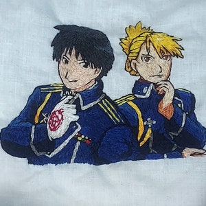 May include: Embroidered image of two anime characters in military uniforms. The character on the left has black hair and is wearing a blue uniform with gold accents. The character on the right has blonde hair and is wearing a blue uniform with gold accents.