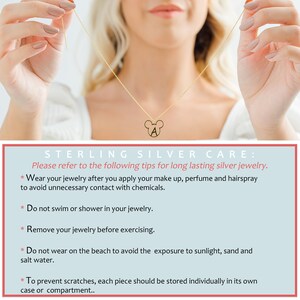May include: A gold necklace with a Mickey Mouse charm featuring the letter A. The necklace is worn by a person with their hands visible. The image includes text that reads "STERLING SILVER CARE: Please refer to the following tips for long lasting silver jewelry. * Wear your jewelry after you apply your make up, perfume and hairspray to avoid unnecessary contact with chemicals. * Do not swim or shower in your jewelry. * Remove your jewelry before exercising. * Do not wear on the beach to avoid the exposure to sunlight, sand and salt water. * To prevent scratches, each piece should be stored individually in its own case or compartment."