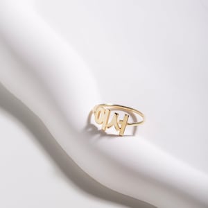May include: Gold ring with the word "LOVE" written in Korean characters.
