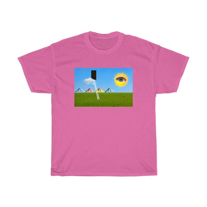 May include: A pink t-shirt featuring a surreal landscape design. The graphic includes a green field, blue sky, a ladder leading to a black rectangle, a cloud, and a sun with an eye. The design also includes colorful triangular shapes.