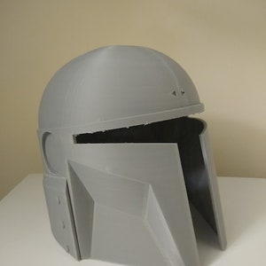May include: A grey 3D printed helmet with a visor and a textured surface.