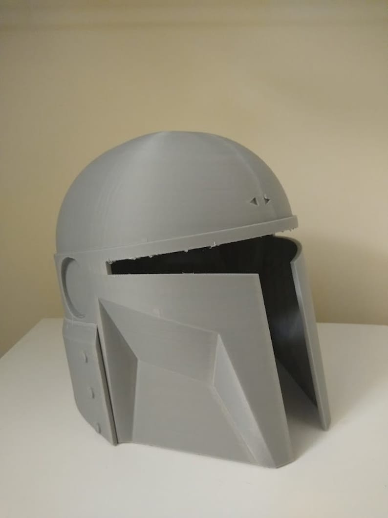 May include: A grey 3D printed helmet with a visor and a textured surface.