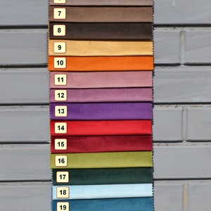 May include: A swatch card with 25 different fabric samples. The samples are arranged in rows, with each row containing a different color. The colors range from white to black, with shades of beige, brown, orange, red, purple, green, blue, and gray in between.