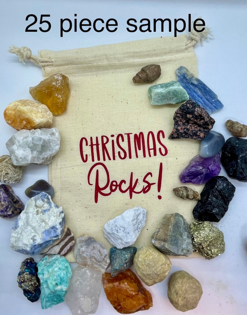 May include: A white drawstring bag filled with 25 assorted rocks and crystals. The bag has the text "CHRISTMAS Rocks!" printed in red on the front.
