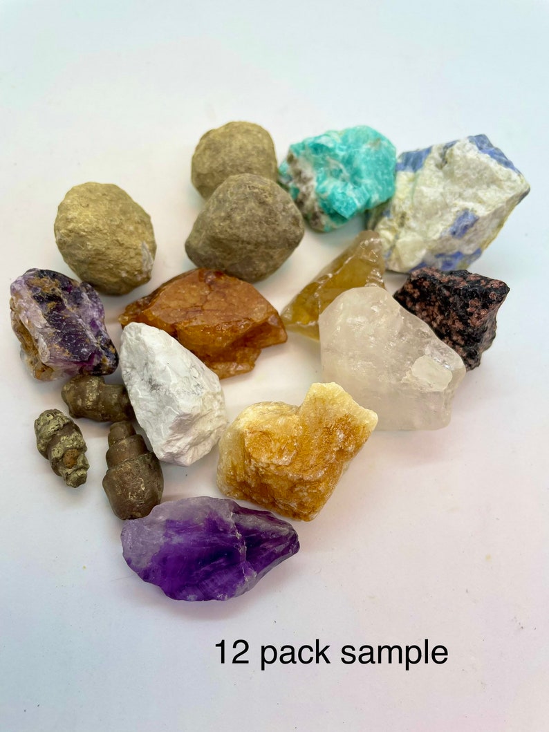 May include: A 12 pack sample of various crystals and stones, including amethyst, citrine, clear quartz, and turquoise. The stones are arranged on a white surface.