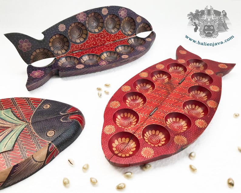 Puede incluir: Tres tableros de juego de madera con forma de pez y dise&ntilde;o plegable con bisagras. Un tablero es rojo con hendiduras circulares, otro es morado oscuro con hendiduras similares y el tercero es un tablero cerrado con patrones pintados complejos.