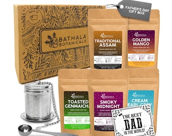 May include: A Bathala Botanicals tea gift set featuring a cardboard box with botanical illustrations, five pouches of loose leaf tea labeled Traditional Assam, Golden Mango, Toasted Genmaicha, Smoky Midnight, and Cream Earl Grey, a metal tea infuser, and a scoop.