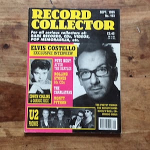 Può includere: Una copertina di rivista per Record Collector, con Elvis Costello in una foto in bianco e nero. La copertina presenta anche foto di Pete Best, The Rolling Stones, The Charlatans, Monty Python e U2. La rivista è di settembre 1995.