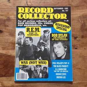 May include: A magazine cover for Record Collector, a magazine for music collectors. The cover features photos of R.E.M., Bob Dylan, and Was (Not Was). The cover text includes the title "Record Collector", the date "September 1992", the issue number "157", and the price "£1.95".