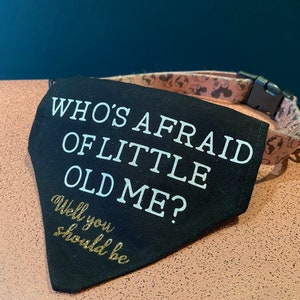 May include: Black dog bandana with white text that reads "Who's Afraid of Little Old Me?" and gold text that reads "Well you should be".