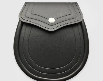 May include: A black leather sporran with a flap closure and a silver-colored button. The sporran has a rounded bottom with three decorative lines and stitched detailing around the flap.