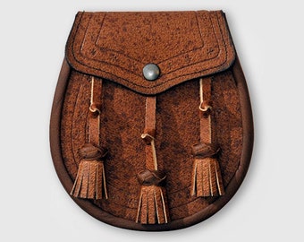 May include: A brown leather sporran with three tassels. The sporran has a flap with a decorative stitching design and a silver button.