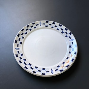 May include: A white ceramic plate with a blue and white geometric pattern around the rim.