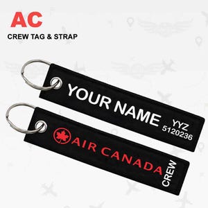 Op de afbeelding: Zwart-witte crew-tag met een rood esdoornbladlogo en de tekst "AIR CANADA CREW". De tag is bevestigd aan een zilveren sleutelhanger. Een tweede zwart-witte tag met de tekst "YOUR NAME YYZ 5120236" is ook bevestigd aan de sleutelhanger.