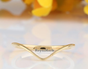 May include: A gold-colored, curved wedding band with the inscription "RoyalMark" on the inside of the band.