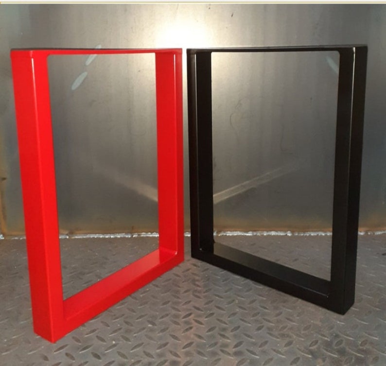 May include: Two metal table legs, one red and one black. The legs are made of square tubing and have a simple, modern design.